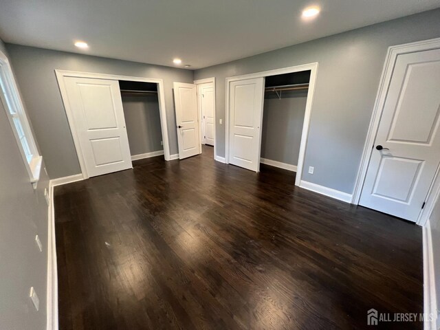 8 Woodlot Rd, East Brunswick, NJ 08816 - unfurnished bedroom with two closets, dark wood-style flooring, recessed lighting, and baseboards