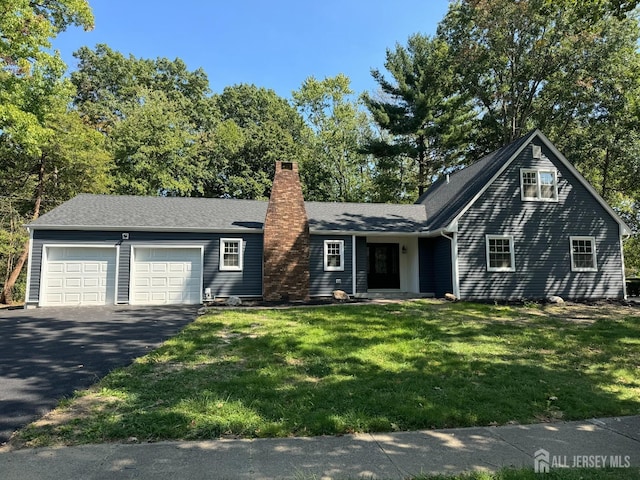 8 Woodlot Rd, East Brunswick, NJ 08816 - view of front of property featuring driveway, an attached garage, a chimney, and a front lawn