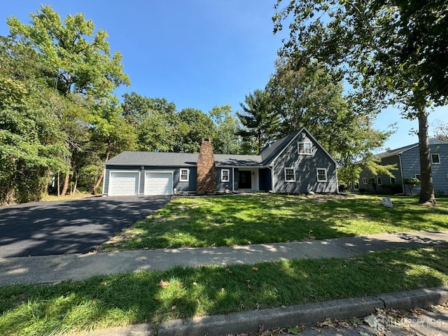 8 Woodlot Rd, East Brunswick, NJ 08816 - view of front of property with driveway, a chimney, a front lawn, and a garage