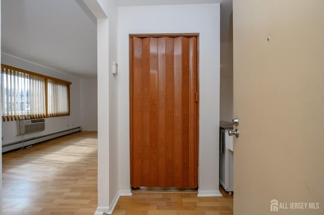 hallway with light wood finished floors and baseboard heating