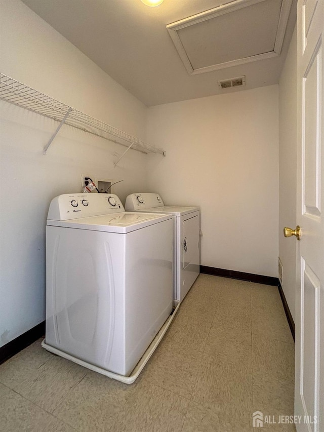 laundry room featuring washing machine and dryer and baseboards