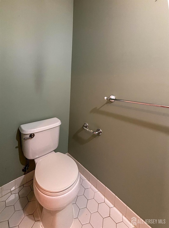 bathroom with toilet, tile patterned floors, and baseboards