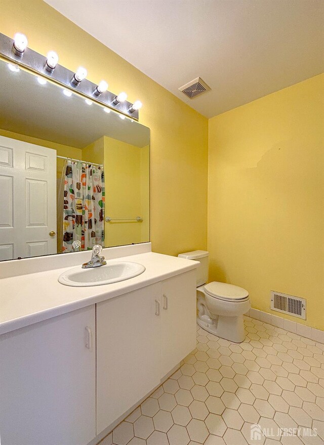full bath featuring toilet, vanity, and curtained shower