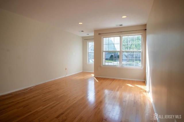 unfurnished room with light wood-style floors, baseboards, and recessed lighting