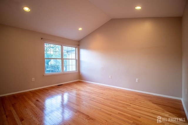 spare room with light wood-style flooring, lofted ceiling, recessed lighting, and baseboards