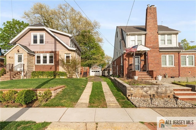 16 Lafayette Ave, Edison, NJ 08837 - view of front of house with a chimney, brick siding, a front yard, and an outbuilding