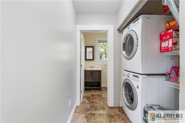 16 Lafayette Ave, Edison, NJ 08837 - laundry area with stacked washing machine and dryer, baseboards, and light stone finish flooring