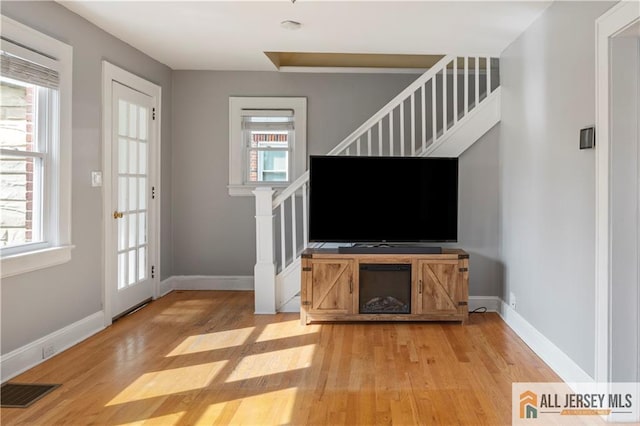 16 Lafayette Ave, Edison, NJ 08837 - unfurnished living room with light wood-style floors, stairway, plenty of natural light, and baseboards