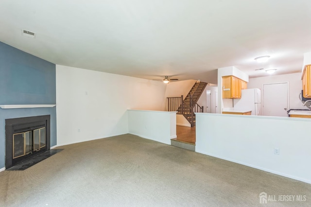 95 Lexington Cir, Old Bridge, NJ 07747 - unfurnished living room with carpet, a fireplace with flush hearth, ceiling fan, a sink, and baseboards