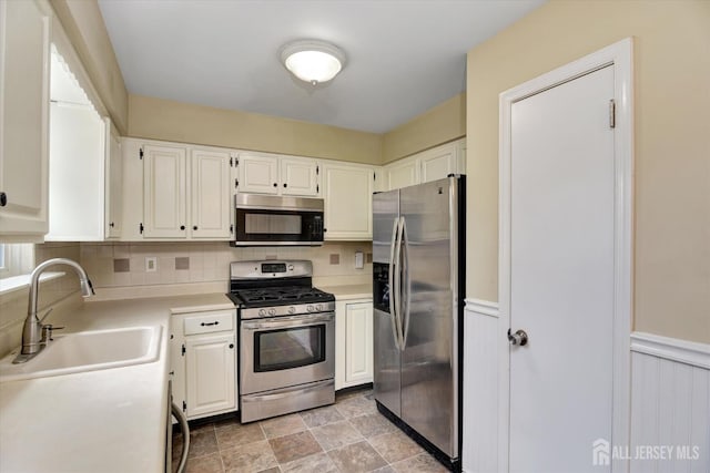 65 Brookview Cir, Jamesburg, NJ 08831 - kitchen featuring decorative backsplash, a sink, light countertops, stainless steel appliances, and white cabinetry