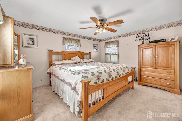 bedroom with ceiling fan and light carpet