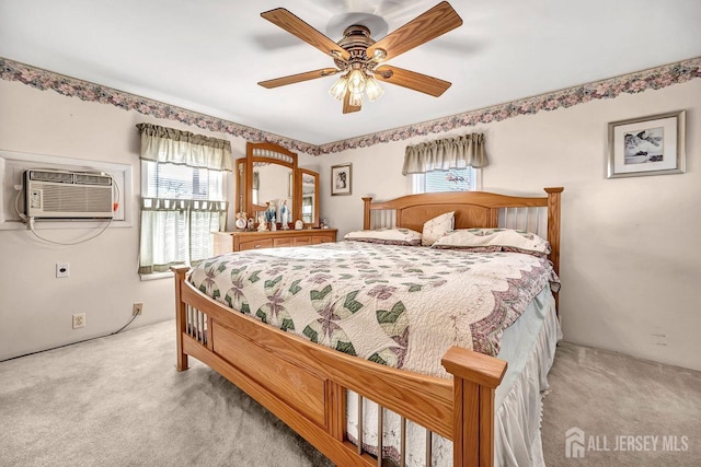 bedroom with light carpet, ceiling fan, and a wall mounted air conditioner