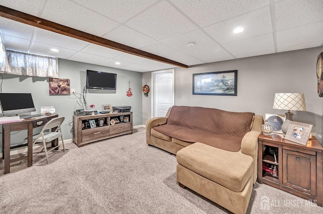 carpeted living room with a paneled ceiling