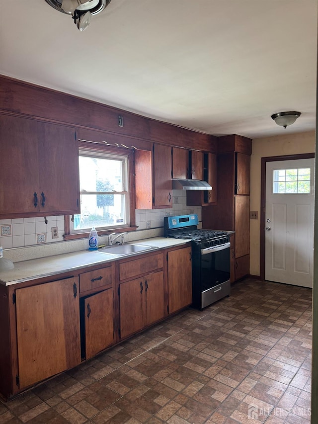 450 Brace Ave, Perth Amboy, NJ 08861 - kitchen with stainless steel range with gas cooktop, under cabinet range hood, brick patterned floors, and backsplash