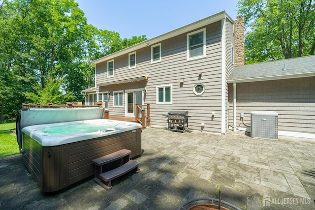 5 Wedgewood Ln, Holmdel, NJ 07733 - back of house with a hot tub, a patio area, and a chimney