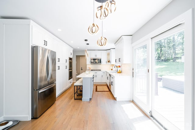 5 Wedgewood Ln, Holmdel, NJ 07733 - kitchen featuring stainless steel appliances, a kitchen bar, light wood-type flooring, light countertops, and recessed lighting