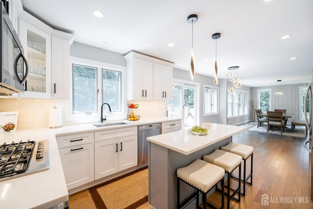 5 Wedgewood Ln, Holmdel, NJ 07733 - kitchen featuring appliances with stainless steel finishes, light countertops, white cabinets, a kitchen breakfast bar, and recessed lighting