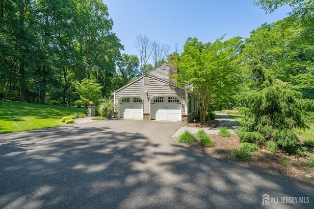 5 Wedgewood Ln, Holmdel, NJ 07733 - view of home's exterior with stone siding, a yard, a chimney, driveway, and an attached garage