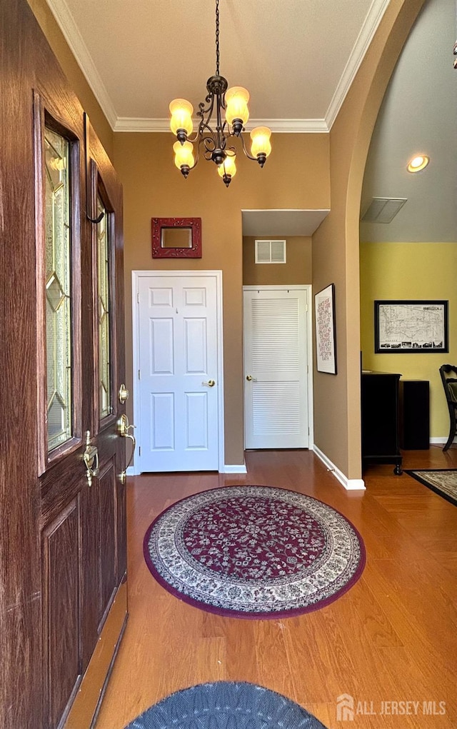 128 Fontaine Ct, Monroe, NJ 08831 - foyer entrance featuring wood finished floors, crown molding, baseboards, a chandelier, and arched walkways