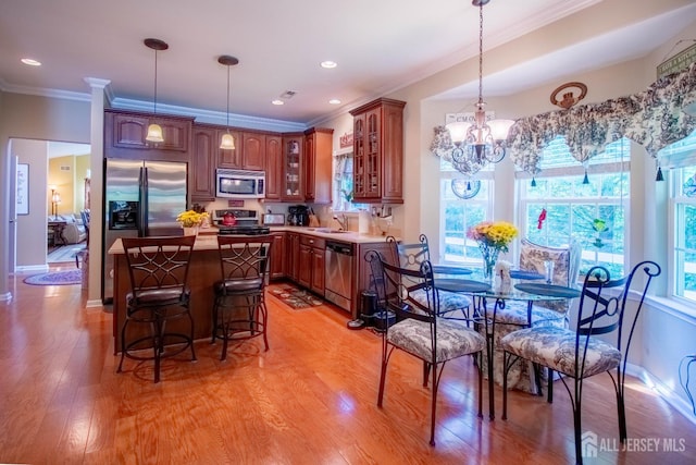 128 Fontaine Ct, Monroe, NJ 08831 - kitchen with appliances with stainless steel finishes, a chandelier, a kitchen island, ornamental molding, and light wood finished floors