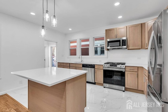 kitchen featuring appliances with stainless steel finishes, a kitchen island, sink, and pendant lighting