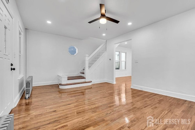 living room featuring radiator, ceiling fan, and light hardwood / wood-style floors