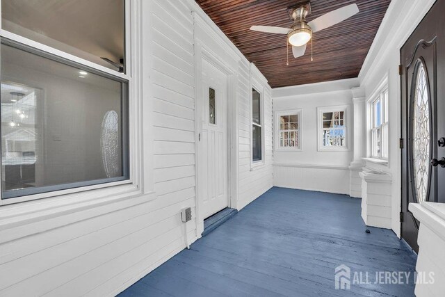 unfurnished sunroom featuring wood ceiling and ceiling fan