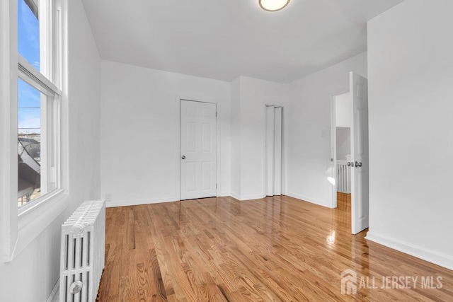 interior space with light hardwood / wood-style floors and radiator heating unit