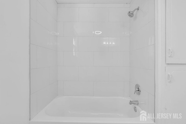 bathroom featuring tiled shower / bath