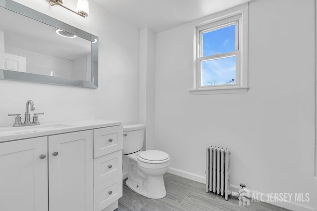 bathroom featuring vanity, radiator, and toilet