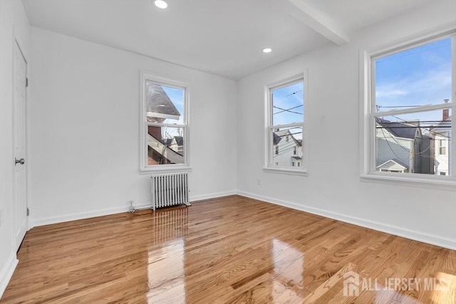 spare room with light wood-type flooring and radiator