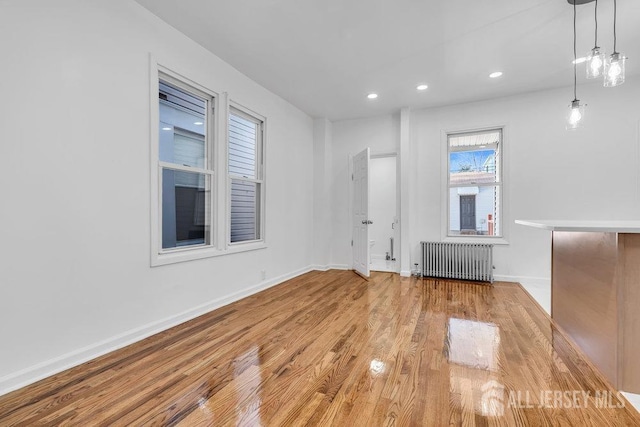 unfurnished living room featuring light hardwood / wood-style floors and radiator