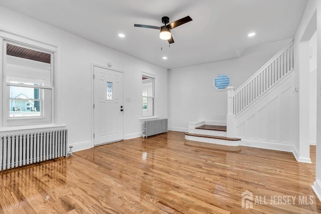 entrance foyer with light hardwood / wood-style floors, plenty of natural light, and radiator