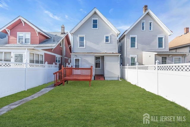 back of property featuring a yard and a deck