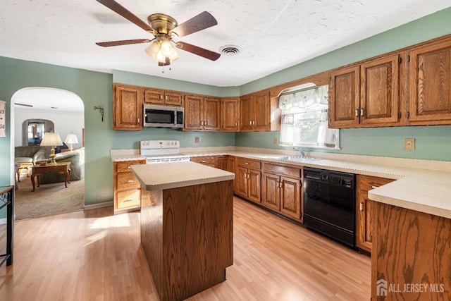 109 Russell St, Woodbridge Proper, NJ 07095 - kitchen featuring stainless steel microwave, black dishwasher, electric range, arched walkways, and brown cabinetry