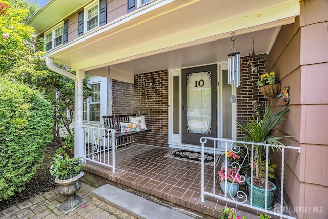 10 Margie Rd, East Brunswick, NJ 08816 - view of exterior entry featuring a porch and brick siding