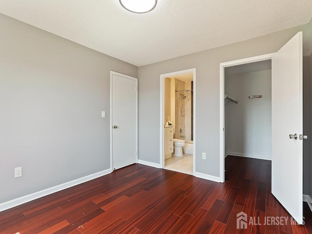 1010 Aspen Dr, Plainsboro, NJ 08536 - unfurnished bedroom with wood finished floors, a spacious closet, baseboards, a closet, and connected bathroom
