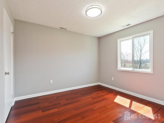 1010 Aspen Dr, Plainsboro, NJ 08536 - empty room with wood finished floors, a textured ceiling, and baseboards