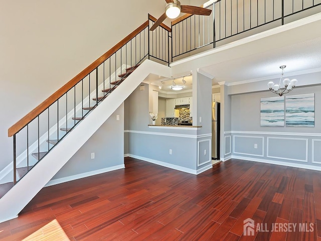 1010 Aspen Dr, Plainsboro, NJ 08536 - unfurnished living room featuring a towering ceiling, ornamental molding, stairway, a chandelier, and wood finished floors