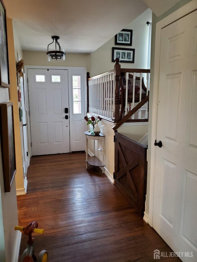 entrance foyer featuring stairway and dark wood-style flooring