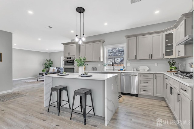 28 Kenmore Rd, Edison, NJ 08817 - kitchen with stainless steel appliances, a breakfast bar, a kitchen island, gray cabinets, and recessed lighting