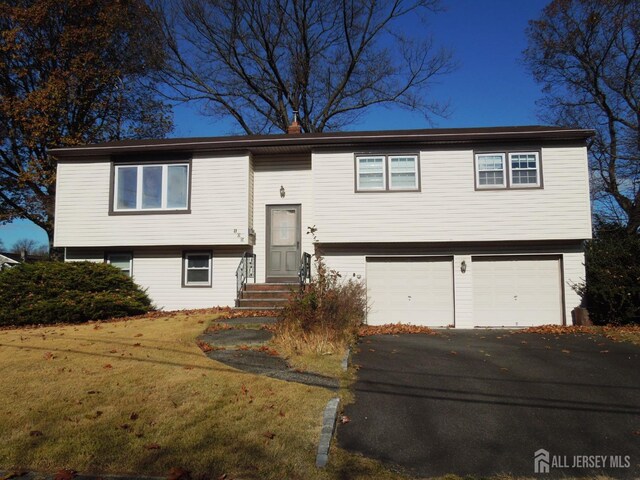 split foyer home with a garage and a front yard