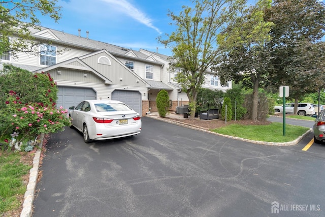 20 Sassafras Ct, North Brunswick, NJ 08902 - townhome / multi-family property with driveway, central AC unit, board and batten siding, and a garage