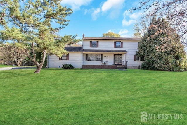 view of property featuring covered porch and a front lawn