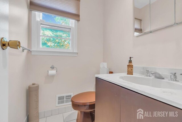 bathroom with toilet, tile patterned flooring, vanity, and visible vents