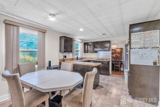 dining area featuring baseboards, stone finish floor, and recessed lighting