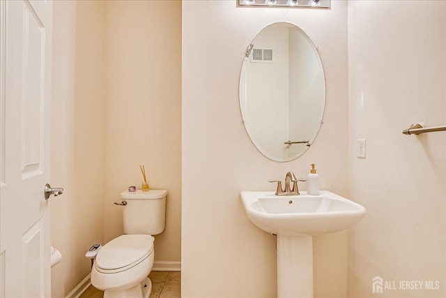 bathroom with tile patterned floors, toilet, and baseboards