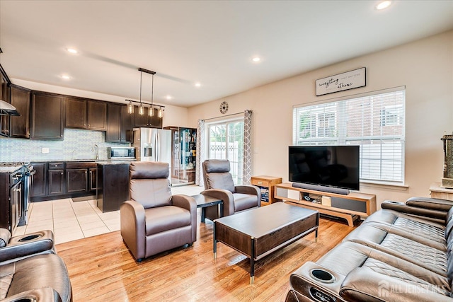 living area with recessed lighting and light wood-style floors