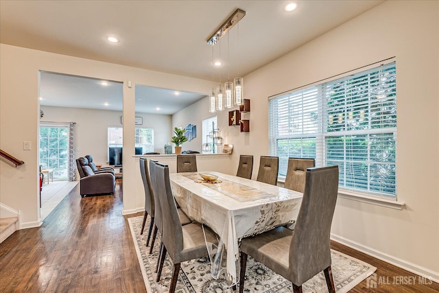 dining area with dark wood-style floors, baseboards, recessed lighting, and stairs