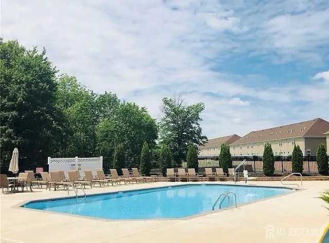 community pool featuring a patio and fence